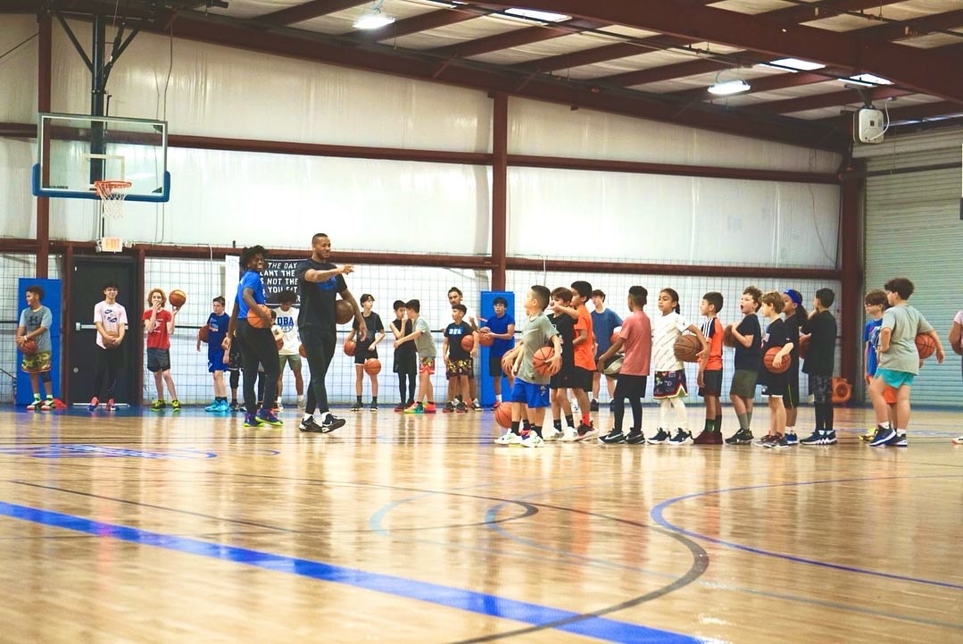 DBA Camps & Clinics — coach instructing youth basketball players on the court